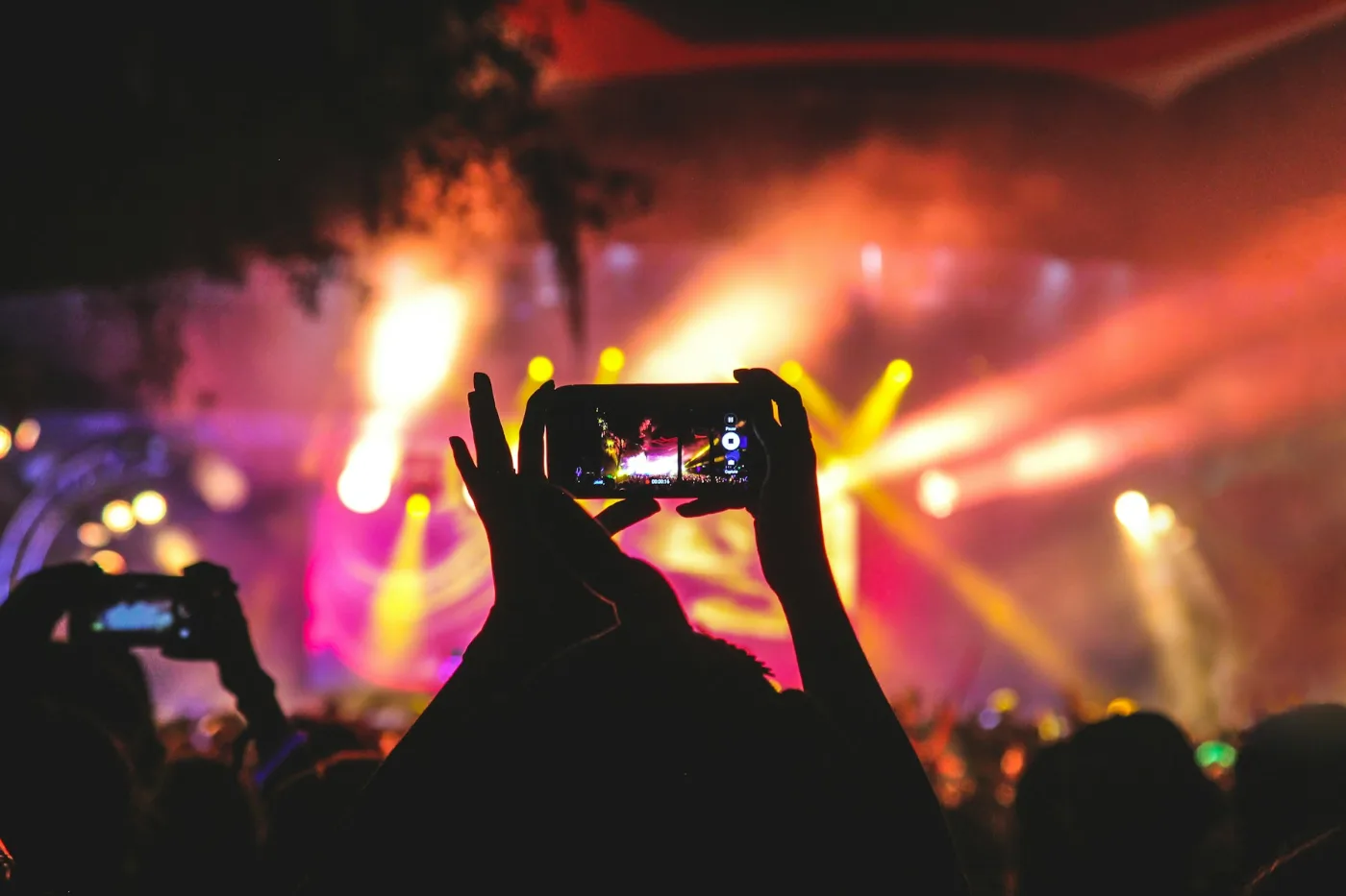 Public de concert éclairé par des écrans de téléphones